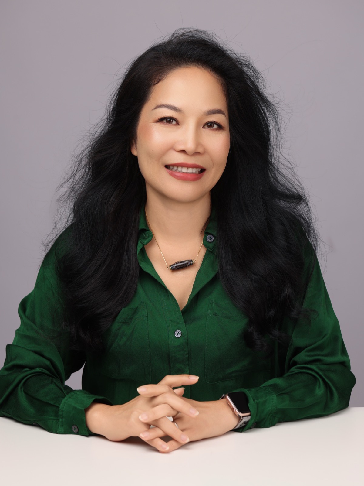 Thu Anh Flynn — leadership and business coach, in deep green